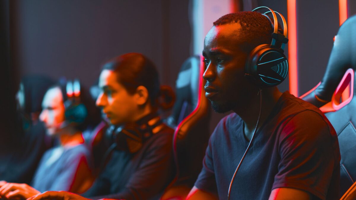 image of people sitting in a line wearing gaming headphones staring at their computers hard at work